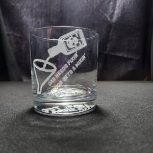 Whiskey glass engraved with the saying "Car Needs Fixin, Liquor needs a mixin" depicting a bottle being poured into a funnel