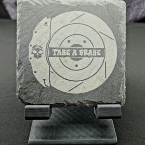 Slate coaster engraved with the image of a brake caliper and rotor and the saying "Take a Brake"
