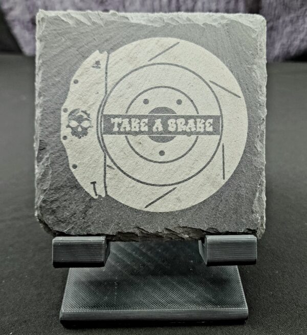 Slate coaster engraved with the image of a brake caliper and rotor and the saying "Take a Brake"